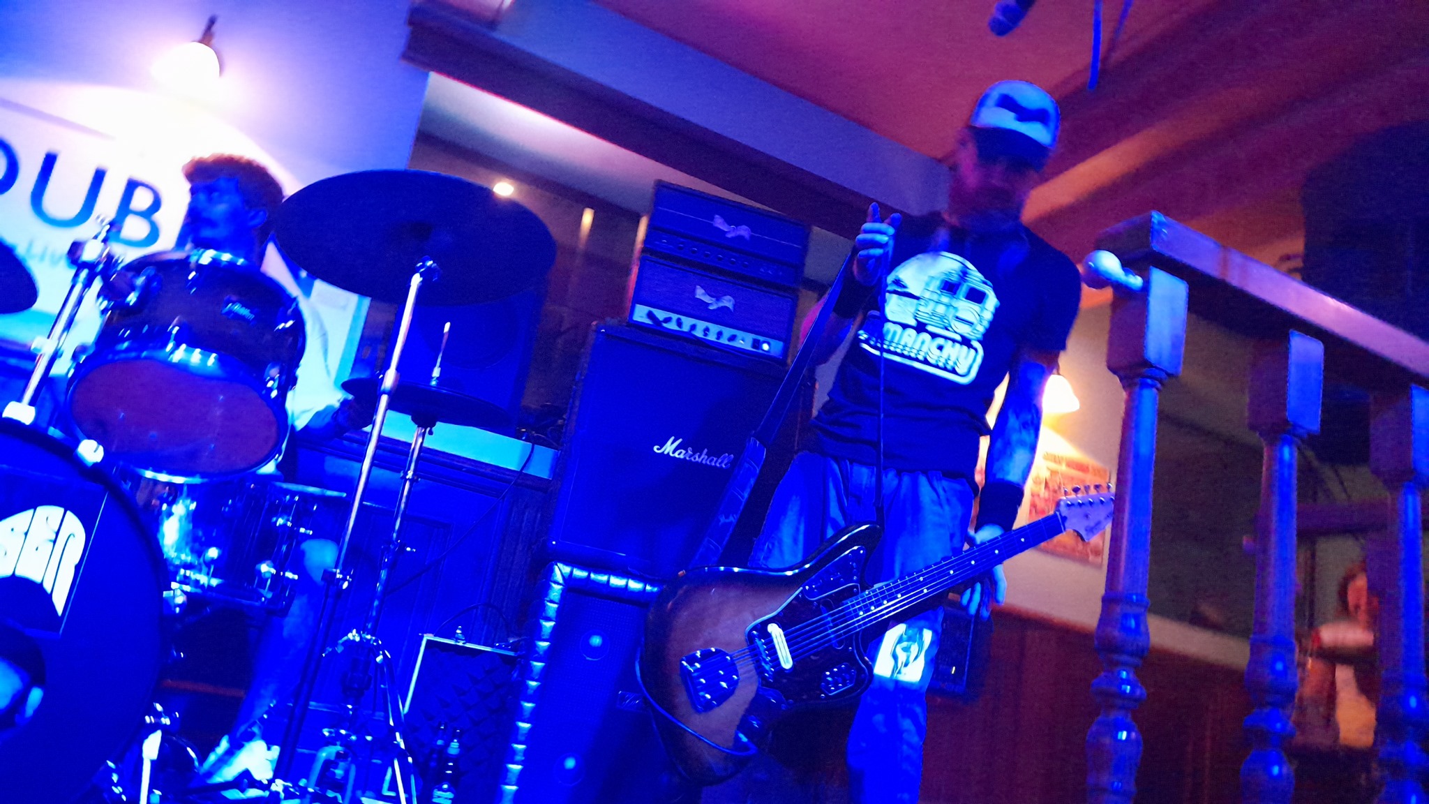 jozz holds his guitar at the strap